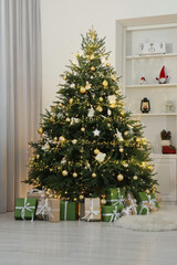 Many gift boxes under Christmas tree decorated with ornaments and festive lights in room