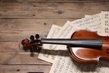 Violin and music sheets on wooden table. Space for text