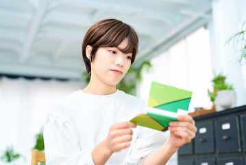通帳を眺める若い女性