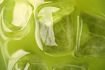 Delicious iced green matcha tea as background, closeup