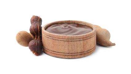 Bowl of tamarind sauce and fresh pods isolated on white