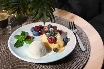 Delicious vanilla fondant served with ice cream and berries on table