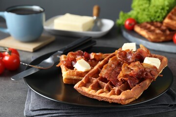 Tasty Belgian waffles served with bacon, butter and coffee on grey table, closeup