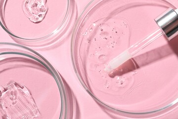 Pipette and petri dishes with serum samples on pink background, flat lay