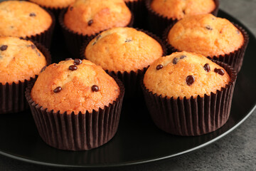 Delicious freshly baked muffins with chocolate chips on table, closeup
