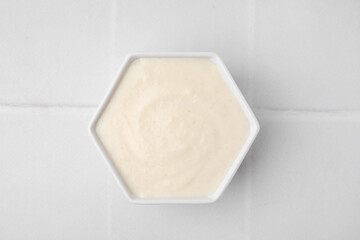 Bowl of delicious semolina pudding on white table, top view