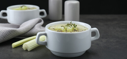 Bowl of delicious celery soup on gray table, closeup. Banner design