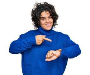 Young hispanic woman with curly hair wearing turtleneck sweater in hurry pointing to watch time, impatience, upset and angry for deadline delay