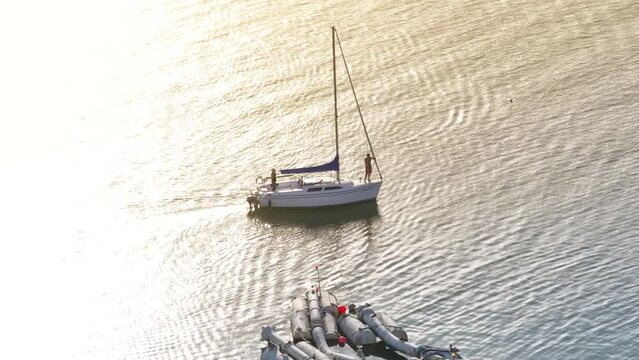 Aerial view of men floating on sailboat Santa Barbara Harbor at the sunset, California, USA. Overhead shot of luxury yacht with people on the board driving in Pacific Ocean. Travel concept, 4k footage