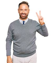 Fototapeta premium Handsome middle age man wearing business clothes showing and pointing up with fingers number two while smiling confident and happy.