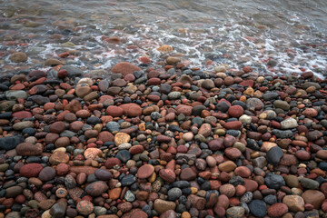 Background of multicolored sea pebbles on the shore of the Baltic Sea, Svetlogorsk, Kaliningrad...