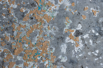 Peeling paint on the wall. Old concrete wall with cracked flaking paint. Weathered rough painted surface with patterns of cracks and peeling. High resolution texture for background and design. Closeup