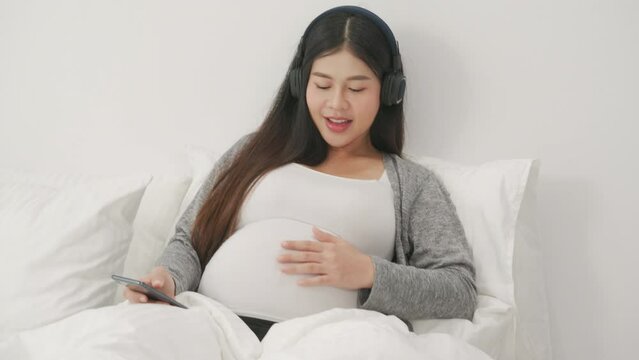 beautiful pregnant woman, sitting on bed in bedroom, preparing to give a birth 