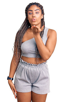 Young african american woman with braids wearing sportswear looking at the camera blowing a kiss with hand on air being lovely and sexy. love expression.
