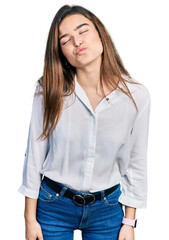 Young caucasian girl wearing casual white shirt looking at the camera blowing a kiss on air being lovely and sexy. love expression.