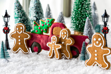 Close up of a gingerbread family scene harvesting a tree for the holidays.