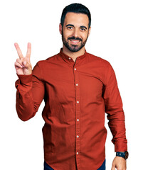 Young hispanic man with beard wearing casual shirt smiling looking to the camera showing fingers...