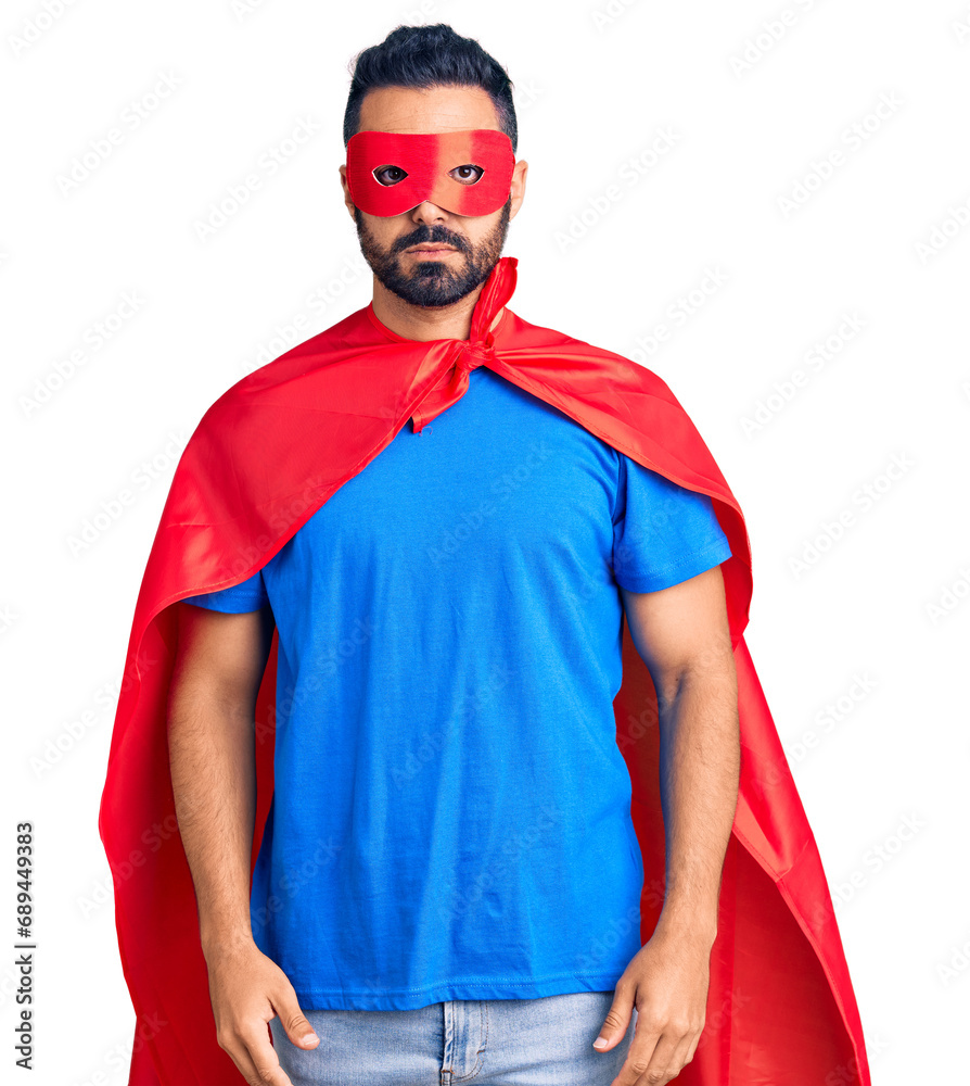 Poster Young hispanic man wearing super hero costume with serious expression on face. simple and natural looking at the camera.