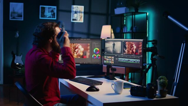Videographer uses software to create visual effects for video projects while relaxing with some music. Professional wearing headphones using post production techniques to edit raw footage
