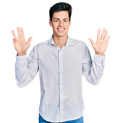 Young hispanic business man wearing business clothes showing and pointing up with fingers number nine while smiling confident and happy.