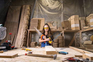 cheerful female carpenter having fun with work tools in the workshop