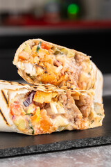 Delicious chicken shawarma with sauce, vegetables and french fries on a cutting board
