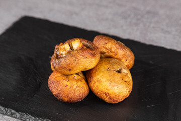 Grilled portobello mushrooms on black  plate, .Brown champignon portobello mushrooms