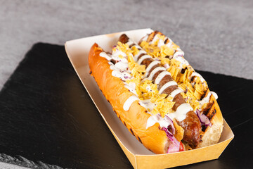 Hot dog with sausages, onions, chips, vegetables and salad on a wooden background. View from above