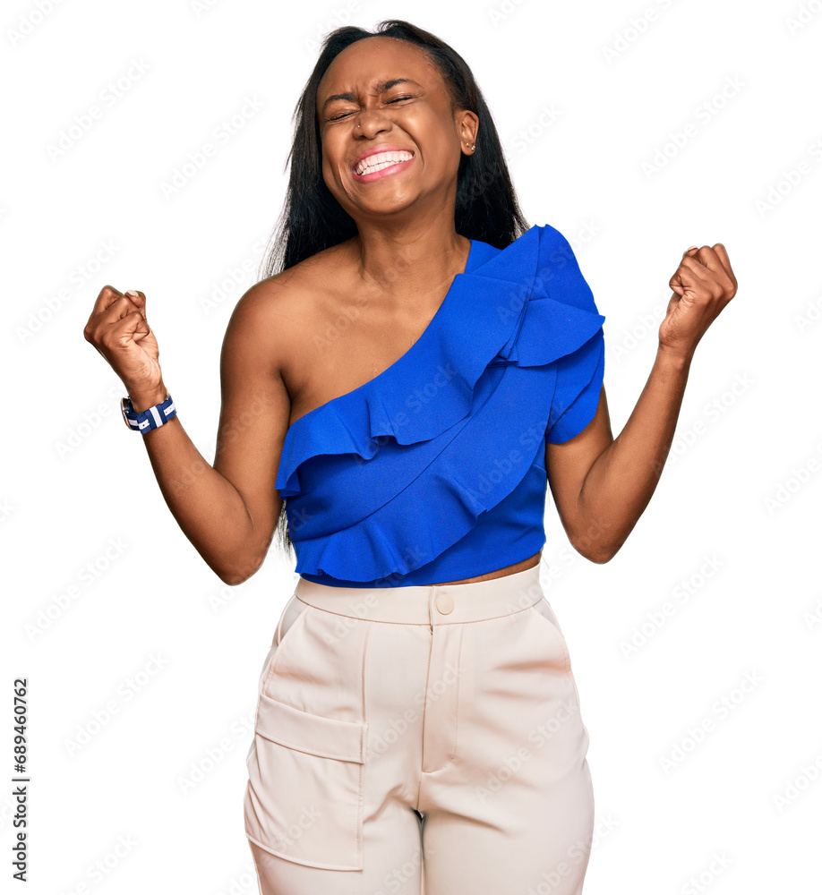 Wall mural young black woman wearing casual clothes very happy and excited doing winner gesture with arms raise