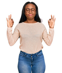 Young black woman wearing casual clothes and glasses relax and smiling with eyes closed doing meditation gesture with fingers. yoga concept.