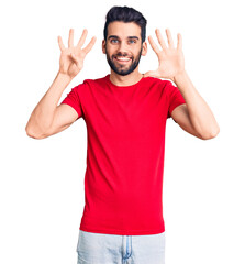 Fototapeta premium Young handsome man with beard wearing casual t-shirt showing and pointing up with fingers number nine while smiling confident and happy.