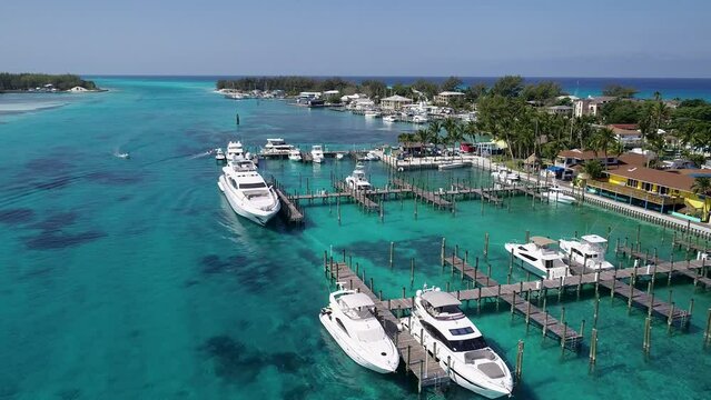 A 4K drone shot of the Bimini Blue Water Marina, in North Bimini, a small island chain found off the coast of the Bahamas. The camera rises and pulls away, revealing more of the island's landscape.