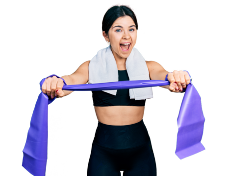 Young brunette woman with blue eyes training arm resistance with elastic arm bands celebrating crazy and amazed for success with open eyes screaming excited.