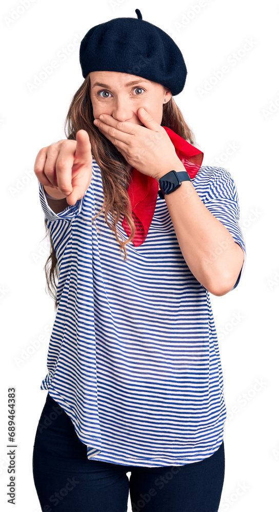 Sticker Young beautiful blonde woman wearing french beret and striped t-shirt laughing at you, pointing finger to the camera with hand over mouth, shame expression