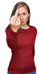 Young blonde woman wearing casual clothes showing middle finger, impolite and rude fuck off...