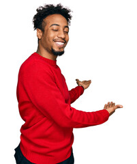 Young african american man with beard wearing casual winter sweater inviting to enter smiling...