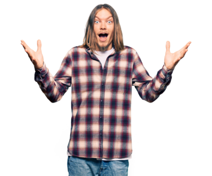 Handsome caucasian man with long hair wearing hipster shirt celebrating crazy and amazed for success with arms raised and open eyes screaming excited. winner concept