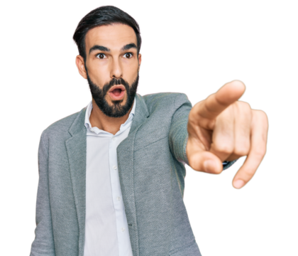 Young hispanic man wearing business clothes pointing with finger surprised ahead, open mouth amazed expression, something on the front
