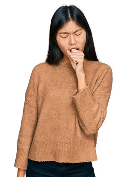 Beautiful young asian woman wearing casual winter sweater feeling unwell and coughing as symptom for cold or bronchitis. health care concept.