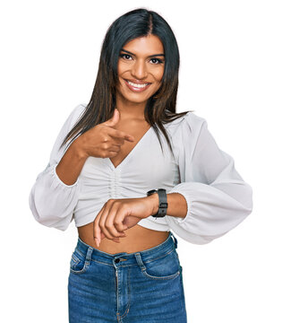 Young latin transsexual transgender woman wearing casual clothes in hurry pointing to watch time, impatience, upset and angry for deadline delay