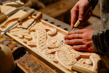This image features a skilled artisan carpenter meticulously carving ornate and intricate patterns...