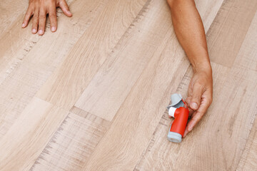 Hand holding asthma inhaler on wooden floor for relief asthma attacks