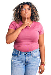 Young african american plus size woman wearing casual clothes thinking concentrated about doubt with finger on chin and looking up wondering