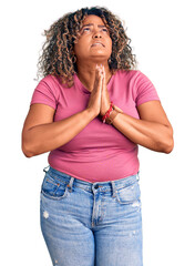 Young african american plus size woman wearing casual clothes begging and praying with hands together with hope expression on face very emotional and worried. begging.