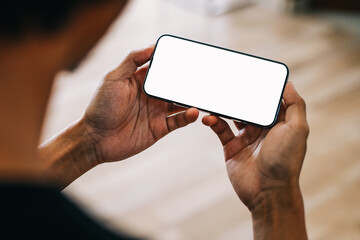 Mockup image of a man holding mobile phone with white blank screen for advertisement.