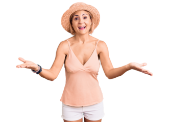 Young blonde woman wearing summer hat smiling cheerful offering hands giving assistance and acceptance.