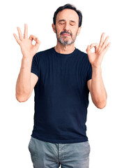 Middle age handsome man wearing casual t-shirt relax and smiling with eyes closed doing meditation gesture with fingers. yoga concept.