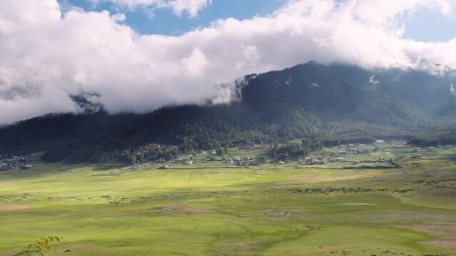 View of scenic landscape with mountains and clouds in Bhutan, view of the meadows in Phobjikha valley in Bhutan.