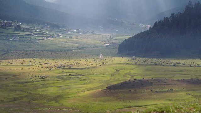 View of scenic landscape with mountains and clouds in Bhutan, view of the meadows in Phobjikha valley in Bhutan.