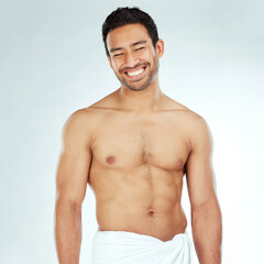 Body, cleaning and happy asian man in a towel in studio for beauty, hygiene and care on grey...